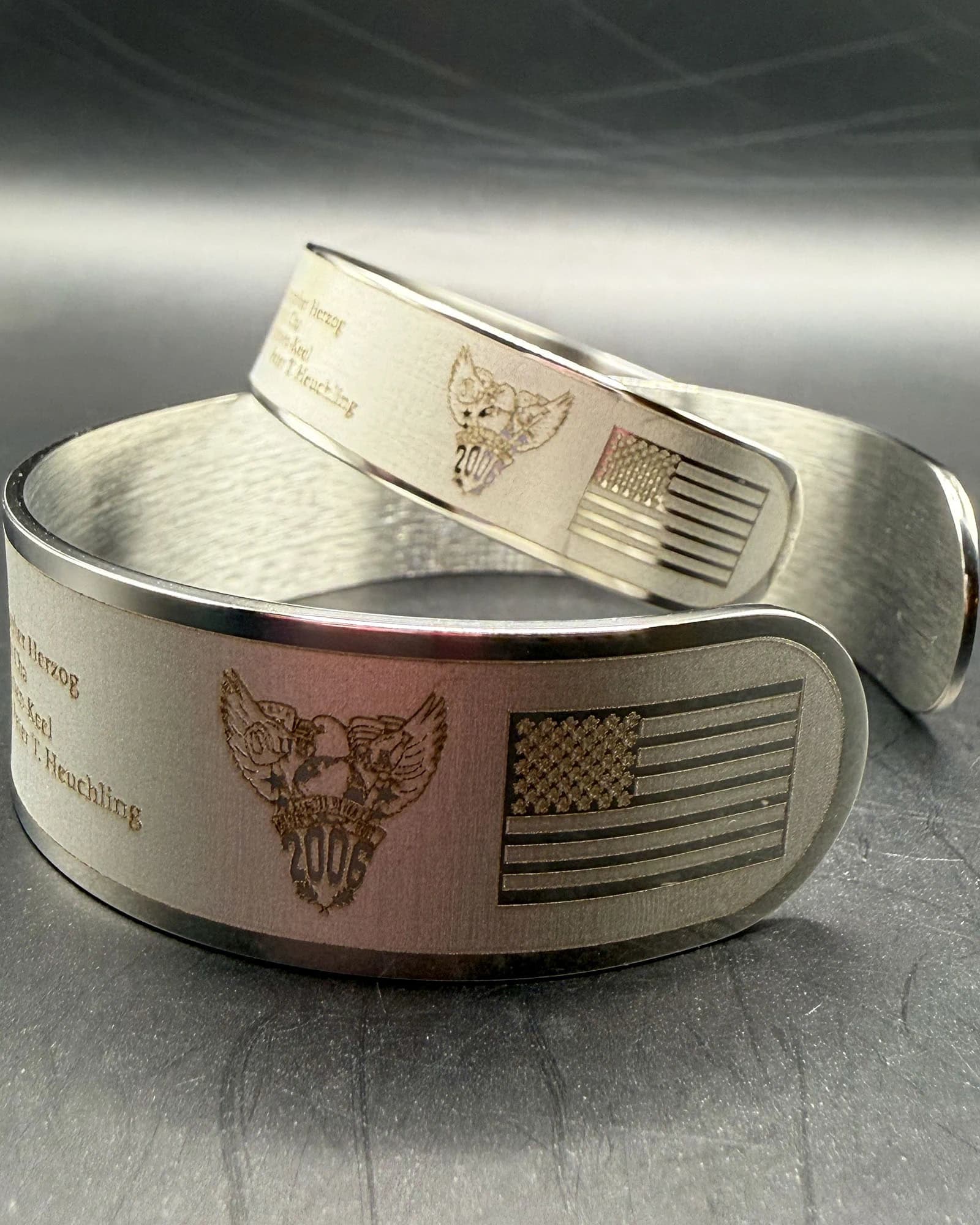 Finished USMA Class of 2006 bracelets showing the class crest and engraved United States flag.